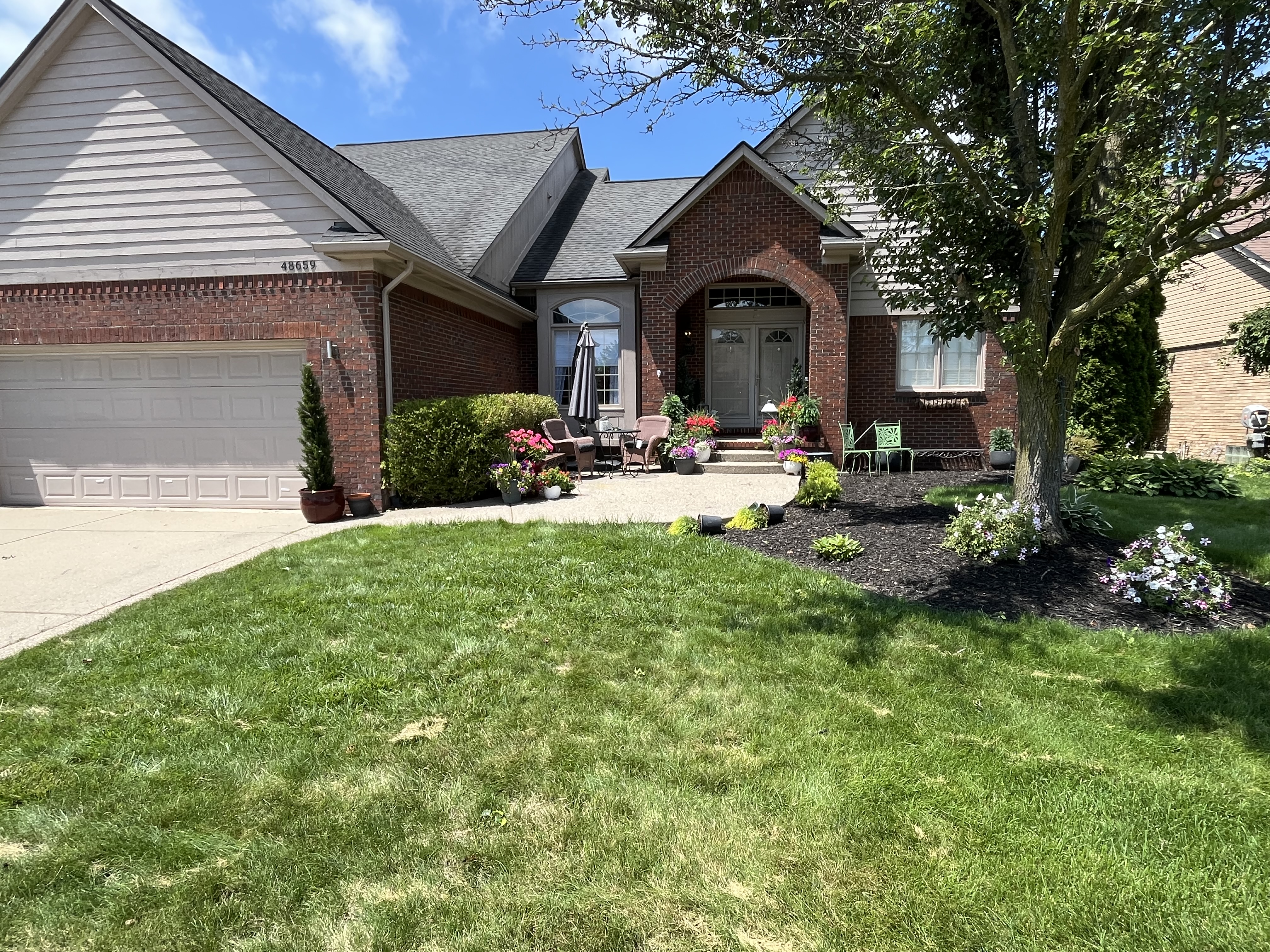 Brick home before exterior painting with light siding and trim